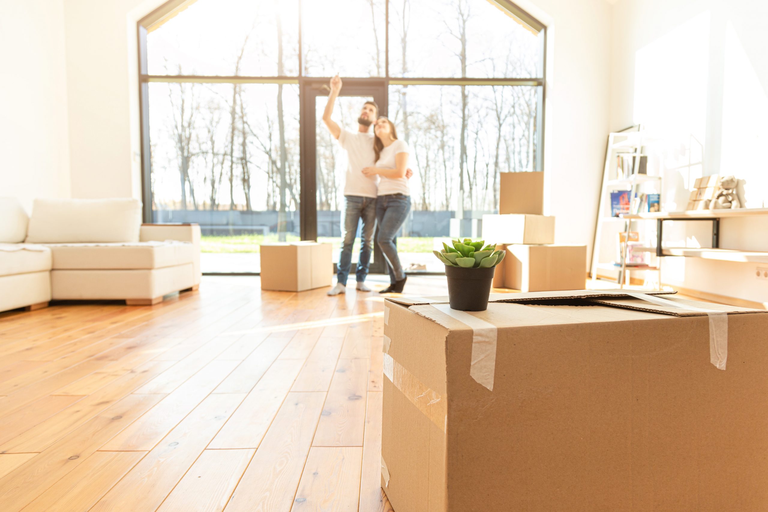 young couple moves to a new home. the family carries boxes of things after buying a home