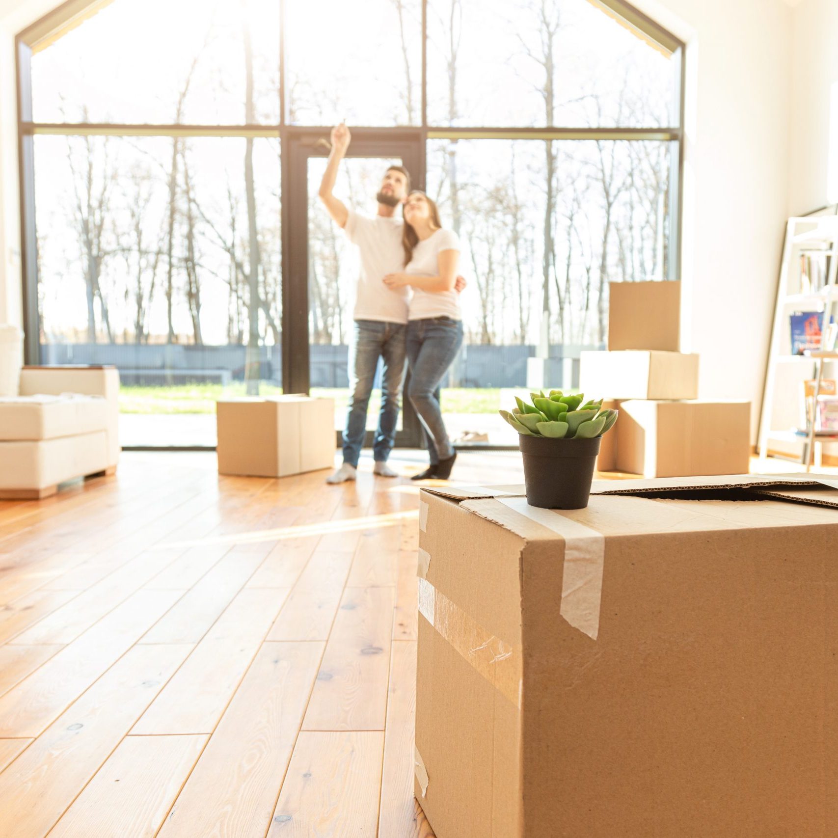 young couple moves to a new home. the family carries boxes of things after buying a home